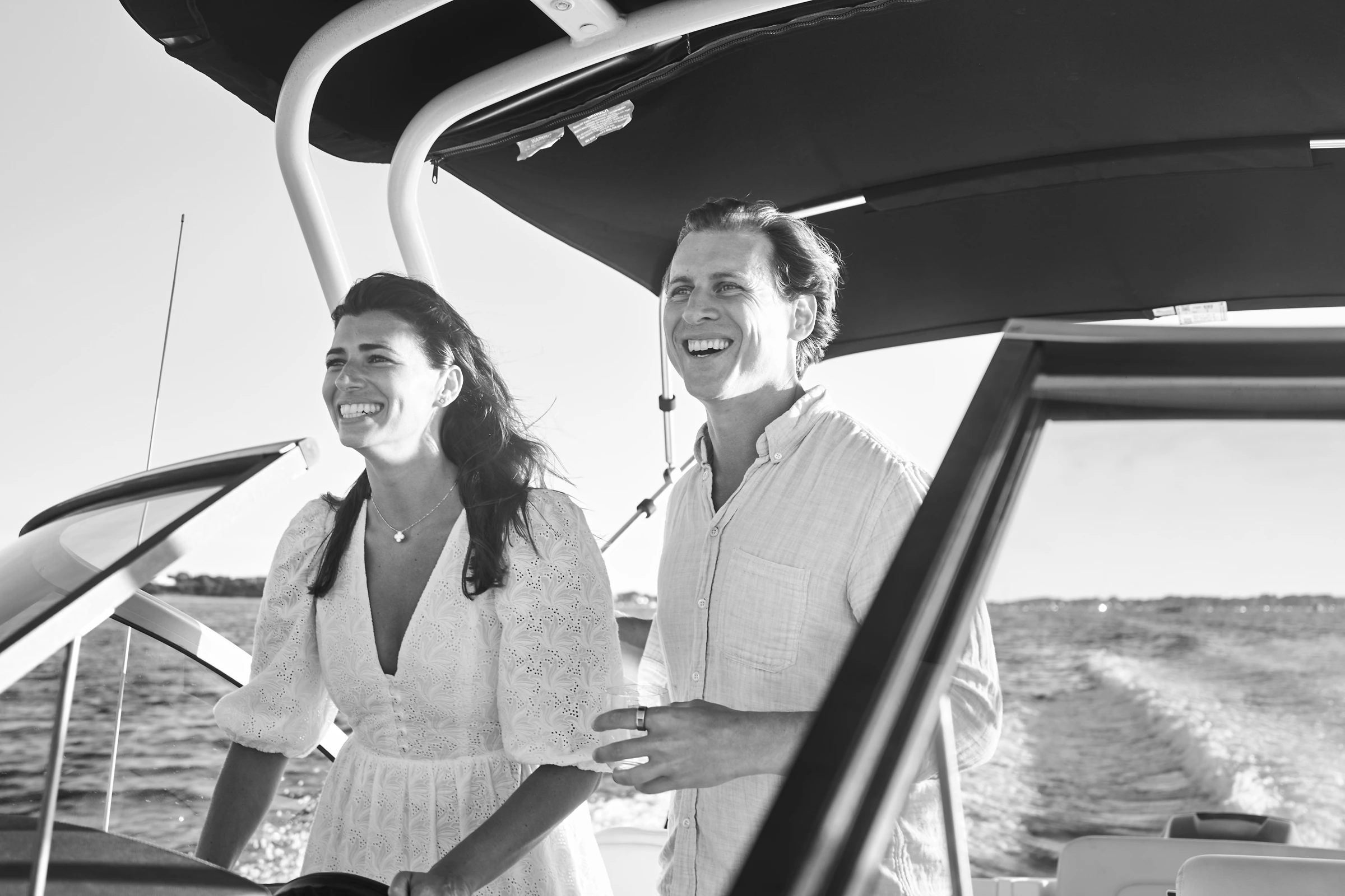 A black-and-white photograph of a couple laughing together aboard a boat in Nantucket